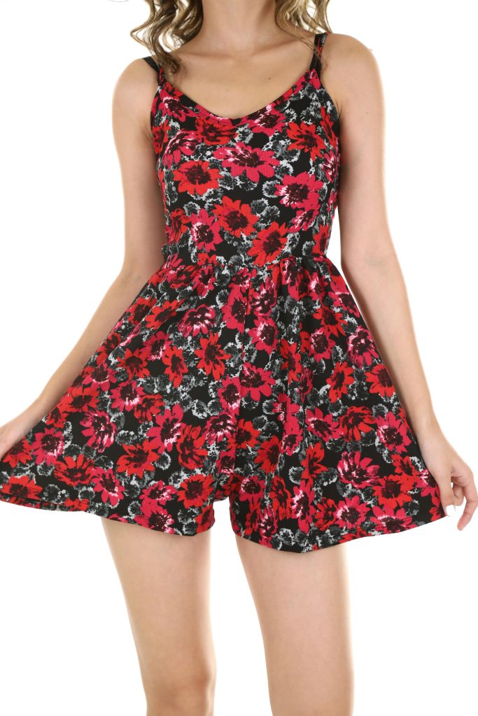 A stylish woman poses in a vibrant floral dress, perfect for summer fashion.